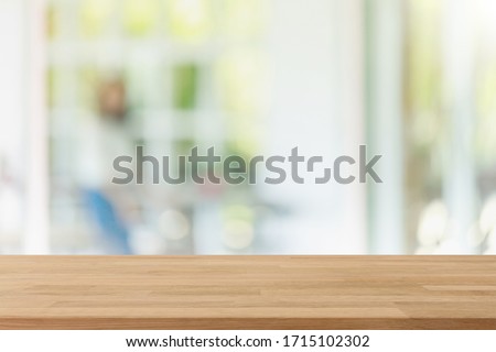 Empty wood table top and blurred of interior restaurant with window view green from tree garden background background - can used for display or montage your products.