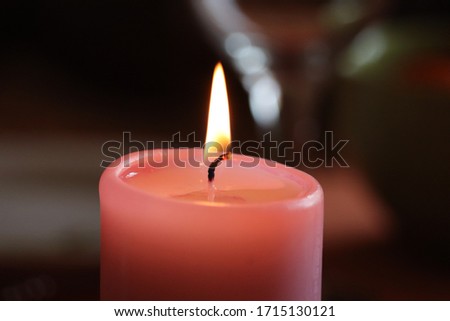 pink burning candle in warm evening colors