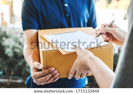 Delivery concept Asian Man hand accepting a delivery boxes from professional deliveryman at home
