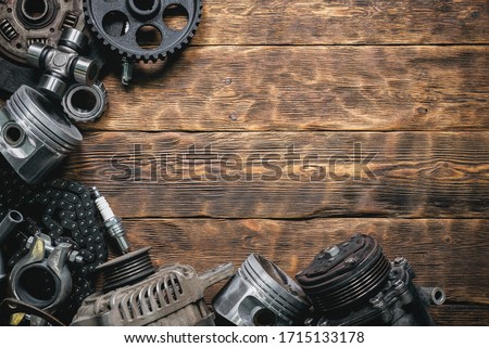 Old car spare parts on wooden flat lay workbench background with copy space.