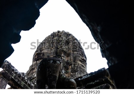 Serene faces carved on stone on top of the Bayon temple pictured from an inside gallery, Angkor Thom, Siem Reap, Cambodia, South east Asia