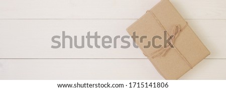 Gift box on wooden background with romantic, presents for mother day or valentine day with pastel tone, package with congratulation, nature for decoration on desk, holiday concept, banner website.