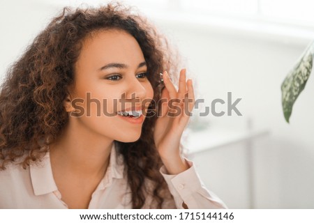 Young African-American woman putting in contact lenses at home Royalty-Free Stock Photo #1715144146