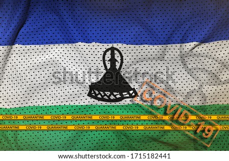 Lesotho flag and orange Covid-19 stamp with border tape. Coronavirus or 2019-nCov virus concept