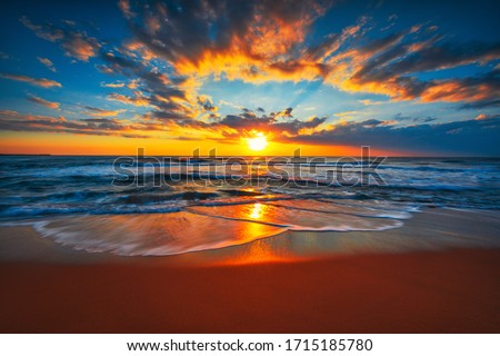 Sunrise on the beach and ocean waves on a tropical sea Royalty-Free Stock Photo #1715185780