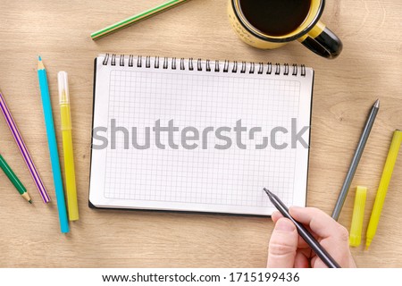Male hand writes action plan or draws in spiral  notebook