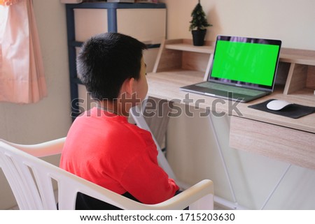 Asian boy stay at home while watching something on laptop