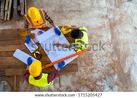 Team engineer and architects are meeting to plan for new project  measuring layout of building blueprints in construction site,working, discussing,planning. Royalty-Free Stock Photo #1715205427