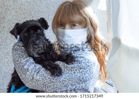  woman with medical mask and disposable gloves with her dog in  home. Safety in public places during outbreak of coronavirus.
