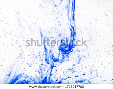 air bubbles on glass surface of flat bottle and blue ink dissolving in water on background
