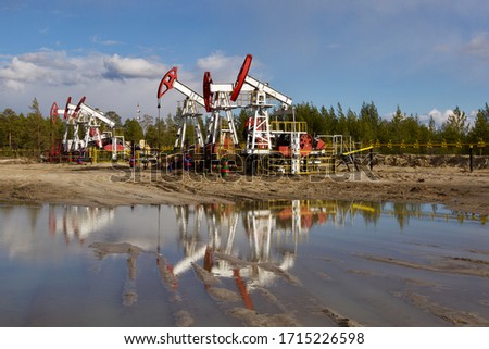 A bunch of inactive oil well pumps in Western Siberia. Idle oil pumpjacks.