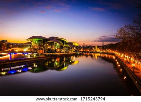 Mtkvari river at night with reflections of Public service hall futuristic building and streets at night in Tbilisi. Travel and architecture in capital of Georgia. 09.04.2020 Royalty-Free Stock Photo #1715243794