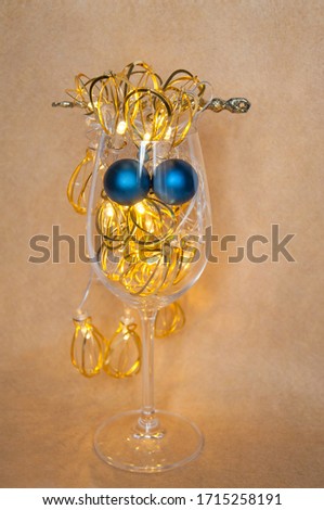 christmas wineglass with decoration garland lights on yellow background copy space concept face blue eyes 
