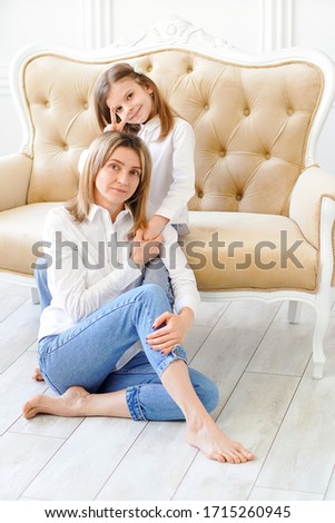Portrait of little girl loving mother and holding her.