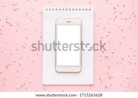 Mobile phone and sweet pastry topping on pink background