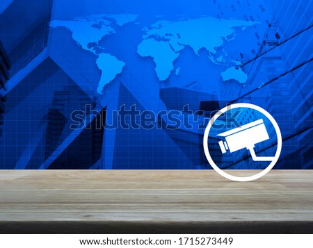 cctv camera flat icon on wooden table over world map, modern city tower and skyscraper, Business security and safety online concept, Elements of this image furnished by NASA
