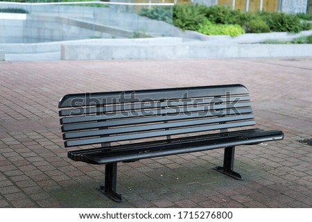 Urban furniture. Outdoor bench or seat. City bench with backrest. Street bench on paving slab. Rest and relax. Enjoy your surrounding.