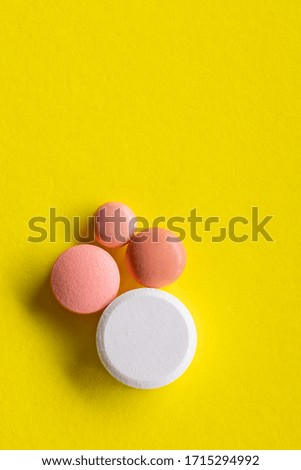 pink pill medicine chest covid-19 cure yellow background close up