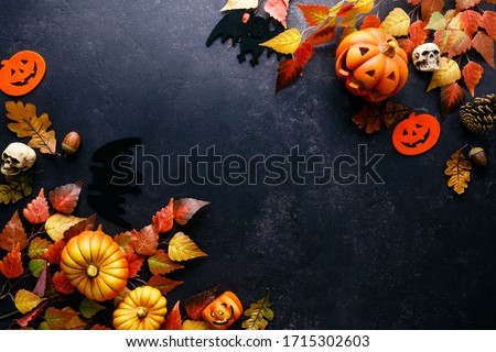 Pumpkins with Halloween decorations on dark background