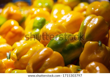 Yellow and green peppers at the market. Pile of yellow bell peppers (sweet peppers) for sale in market. Food Background