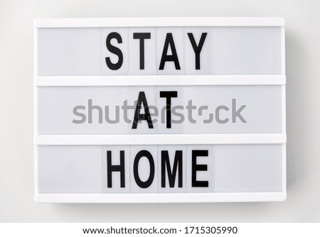 medicine, epidemic and healthcare concept - lightbox with stay at home caution words on white background