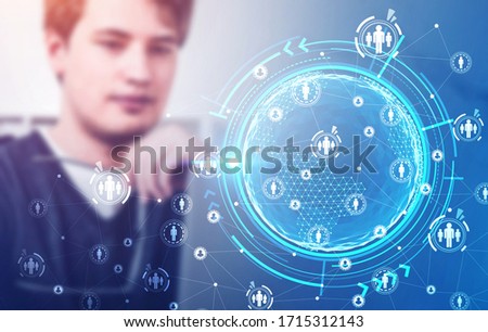 Blurry businessman using laptop in room with double exposure of immersive social network interface. Concept of recruitment. Toned image