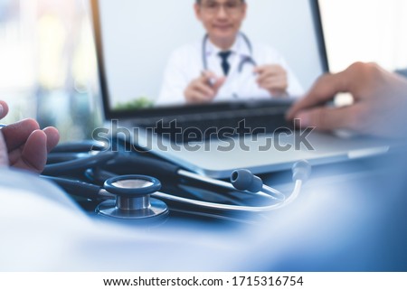 Doctor on video conference or teleconference, discussing on case study via laptop computer in doctor room. Medical team on webinar using zoom online meeting app, Telemedicine, medical technology Royalty-Free Stock Photo #1715316754