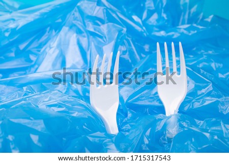 Social environmental issue. Plastic pollution of the planet. White plastic on a blue background. Ecological catastrophy. Sorting and processing of a stick. Plastic waste in the environment.Eco-problem