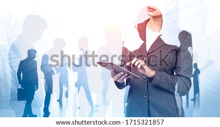 Unrecognizable businesswoman using tablet in city with double exposure of her teammates in background. Concept of leadership. Toned image