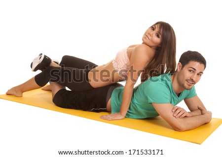 A man and woman laying on a fitness mat.  The woman is laying on her man's back.