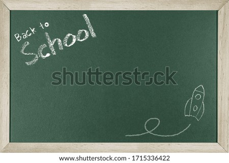Word Back to school and rocket written on chalk board.