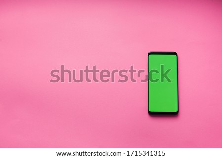 concept of social technologies, smartphone with a green screen on a pink background, chromakey