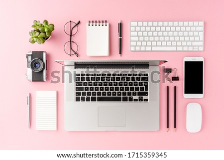 Overhead shot of modern workspace concept with laptop and business accessories on pink background. Office desktop. Flat lay