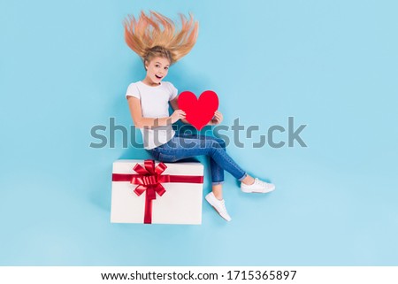 Top above high angle view full length photo astonished crazy girl sit lay big giftbox hold paper card heart she get 14-february holiday wear denim white isolated over blue color background