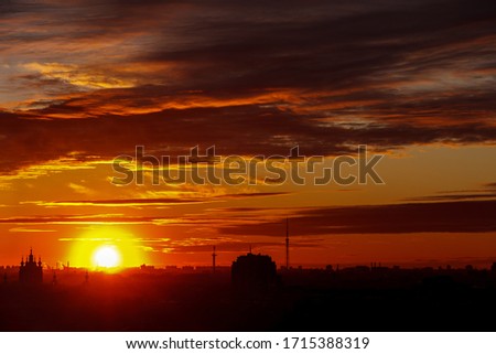 Beautiful colorful sunset over the city horizon. Magnificent clouds over the contours of buildings. Place for your signature. You can use it for business cards, flyers, and backgrounds.