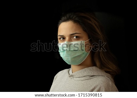 Girl in respiratory mask. Masked woman looks at camera. Cold, flu, virus, tonsillitis, respiratory disease, quarantine, epidemic concept.