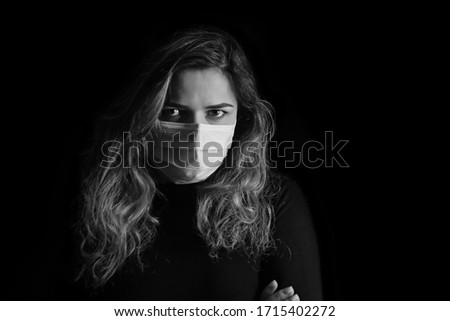 black and white art photography monochrome, girl with a medical mask on a black background, woman doctor, woman with intense look