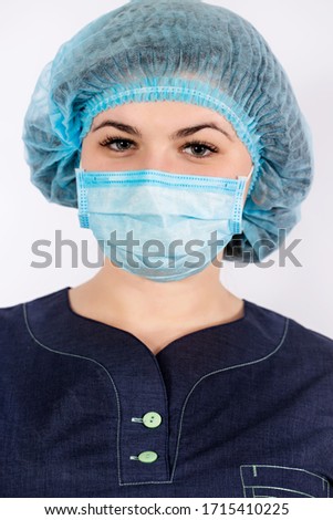 Nurse wearing a medical cap puts on a protective mask. Coronovirus Protection Concept
