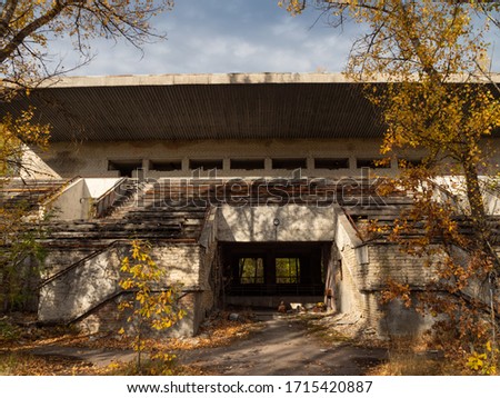 Abandoned tribune of sport stadium Avangard, taken by nature in Pripyat ghost town in Chernobyl Exclusion Zone. Ukraine