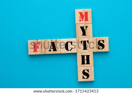 Facts and myths in wooden blocks on blue background. Concept crossword clues