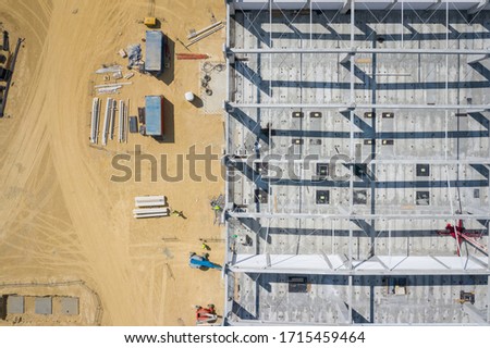 Construction site from above. Top view of factory under construction with heavy machinery. Picture made by drone from above.