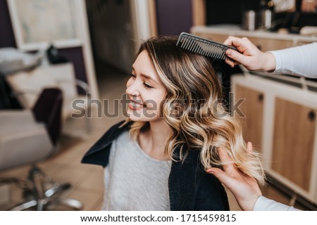 Beautiful hairstyle of young woman after dyeing hair and making highlights in hair salon. Royalty-Free Stock Photo #1715459815