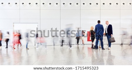 Business team talks in crowd between anonymous business people at a trade show
