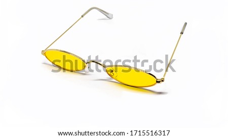 Yellow narrow sunglasses when unfolded on a white background