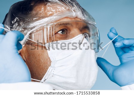 doctor in protective clothing on blue background. close up