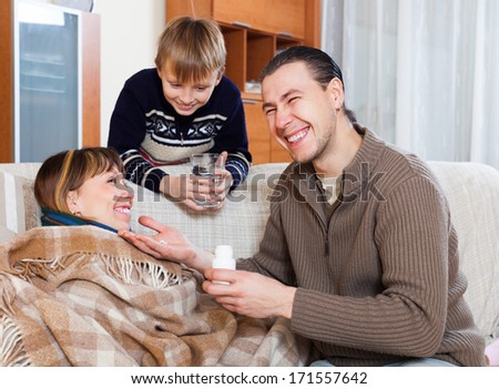 Happy man giving  tablets to unwell wife at home