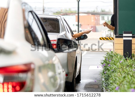 Hand of woman is wearing plastic gloves to prevent or protect the corona virus from paying  by card for coffee or food by driving through or drive thru. (Social distancing) Royalty-Free Stock Photo #1715612278