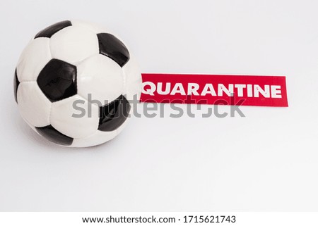 soccer ball near paper with quarantine lettering on white