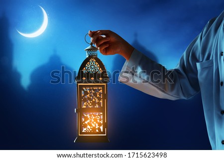 Muslim man holding arabic lantern, Ramadan kareem background Royalty-Free Stock Photo #1715623498