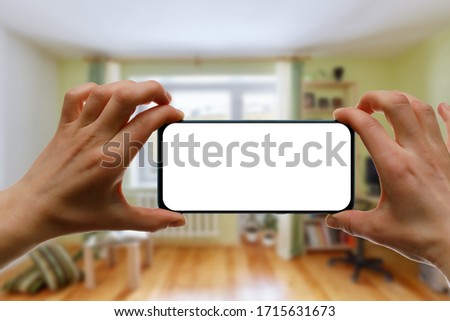 Mockup of using a smartphone in the home interior. Blank white screen for your idea